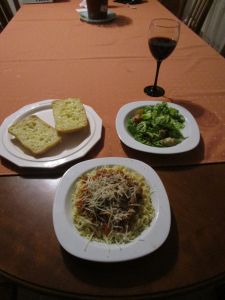 Homemade pasta and pasta sauce with parmesan cheese, cheesy garlic bread, & caesar salad with homemade croutons